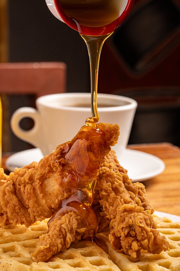 Crispy fried chicken on waffles, topped with syrup, perfect for breakfast or brunch.