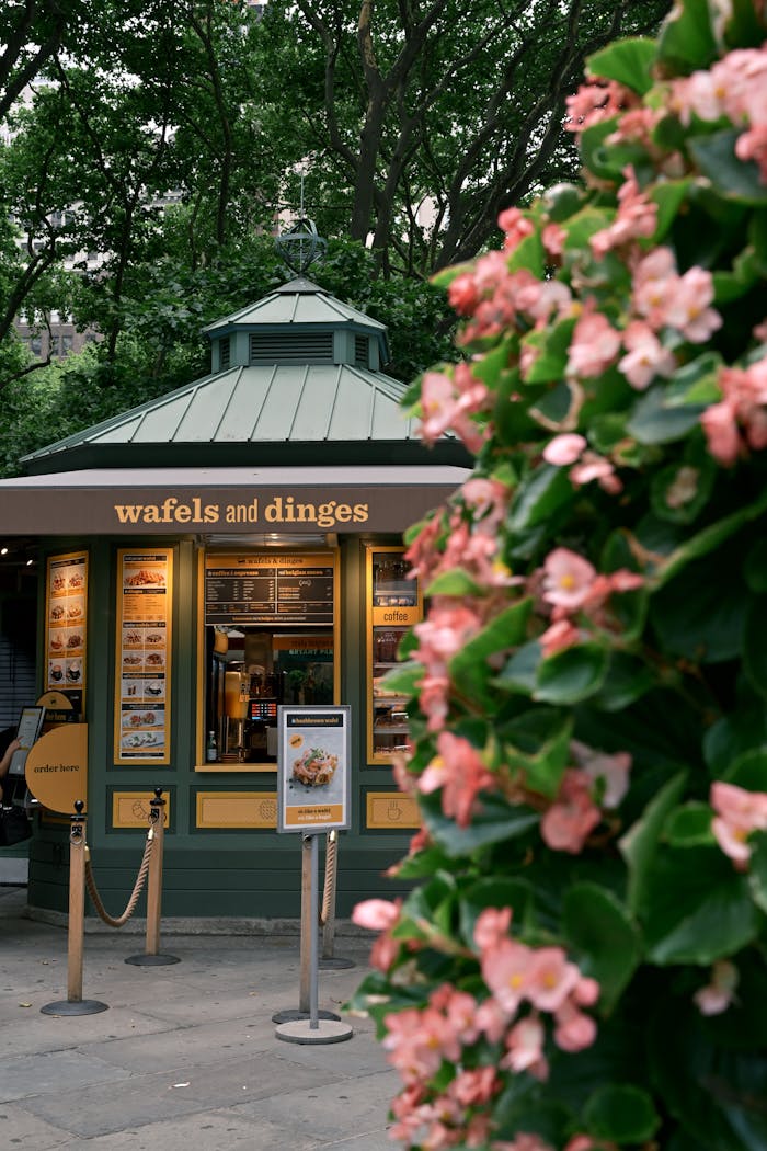 A vibrant waffle stand in a park setting, highlighting summer blooms and inviting treats.